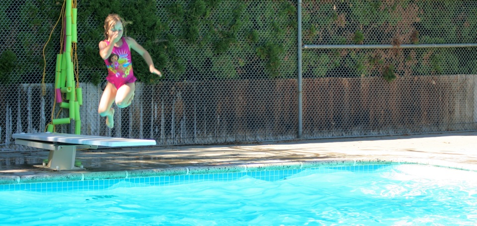 girl jumping into the pool